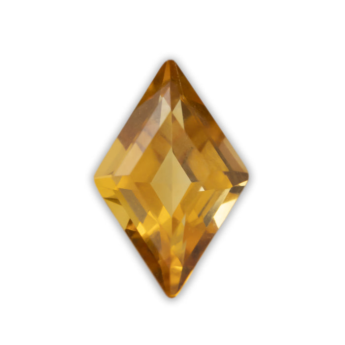A lozenge cut yellow citrine on a white background